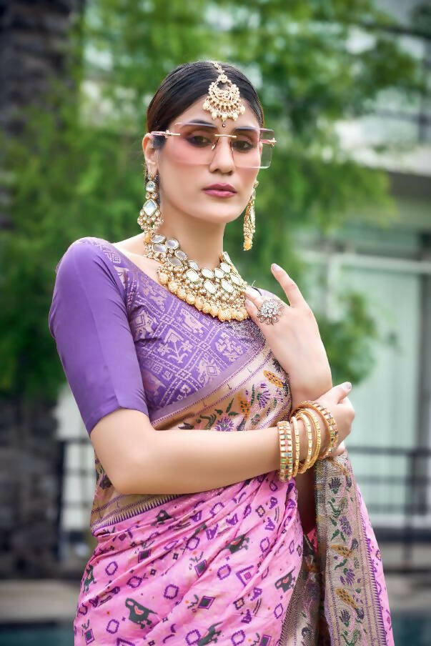 a beautiful Indian model wearing gold jewelry in purple and green sarees  lighting Diyas near an Indian palace pool